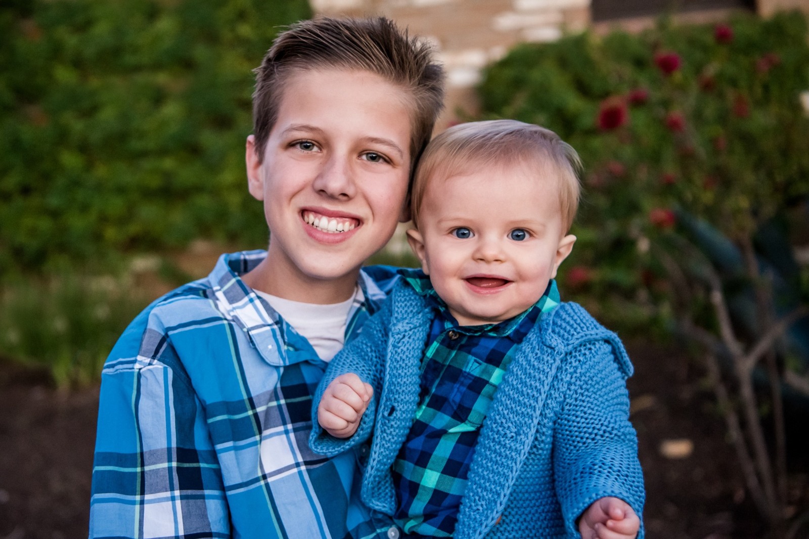 A young boy and a baby smiling together